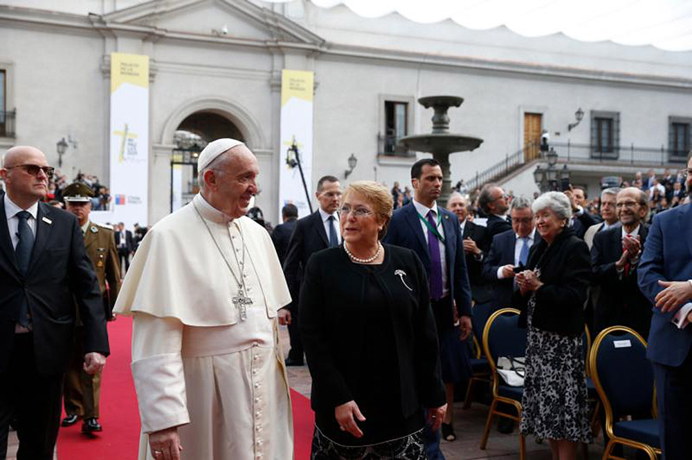 Pope Francis walks with Chilean President Michelle Bachelet after arriving for a meeting with government authorities, members of civil society and the diplomatic corps Jan. 16 at La Moneda presidential palace in Santiago. PAUL HARING/CNS